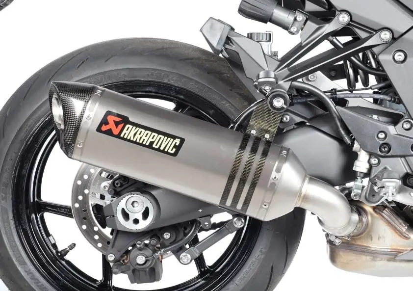 Tłumik zamontowany na motocyklu z zapiętą obejmą.