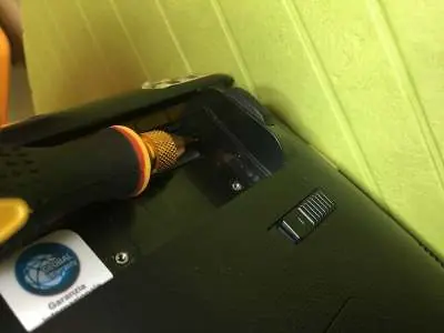 Odkręć śrubę mocującą pod baterią.